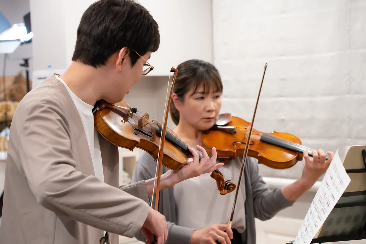 先生と大人の生徒が並んで演奏するレッスン